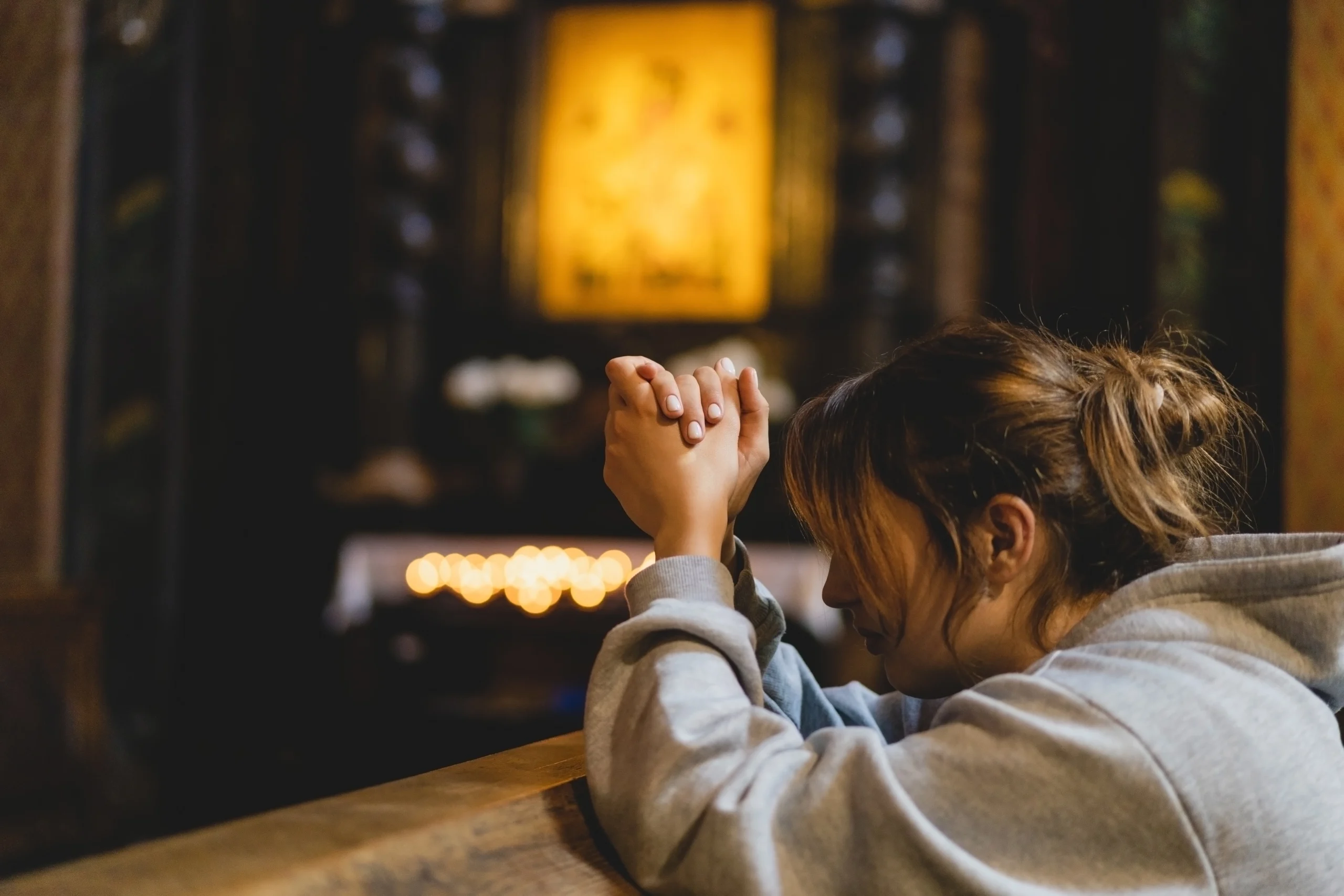 women praying on her knees in a church