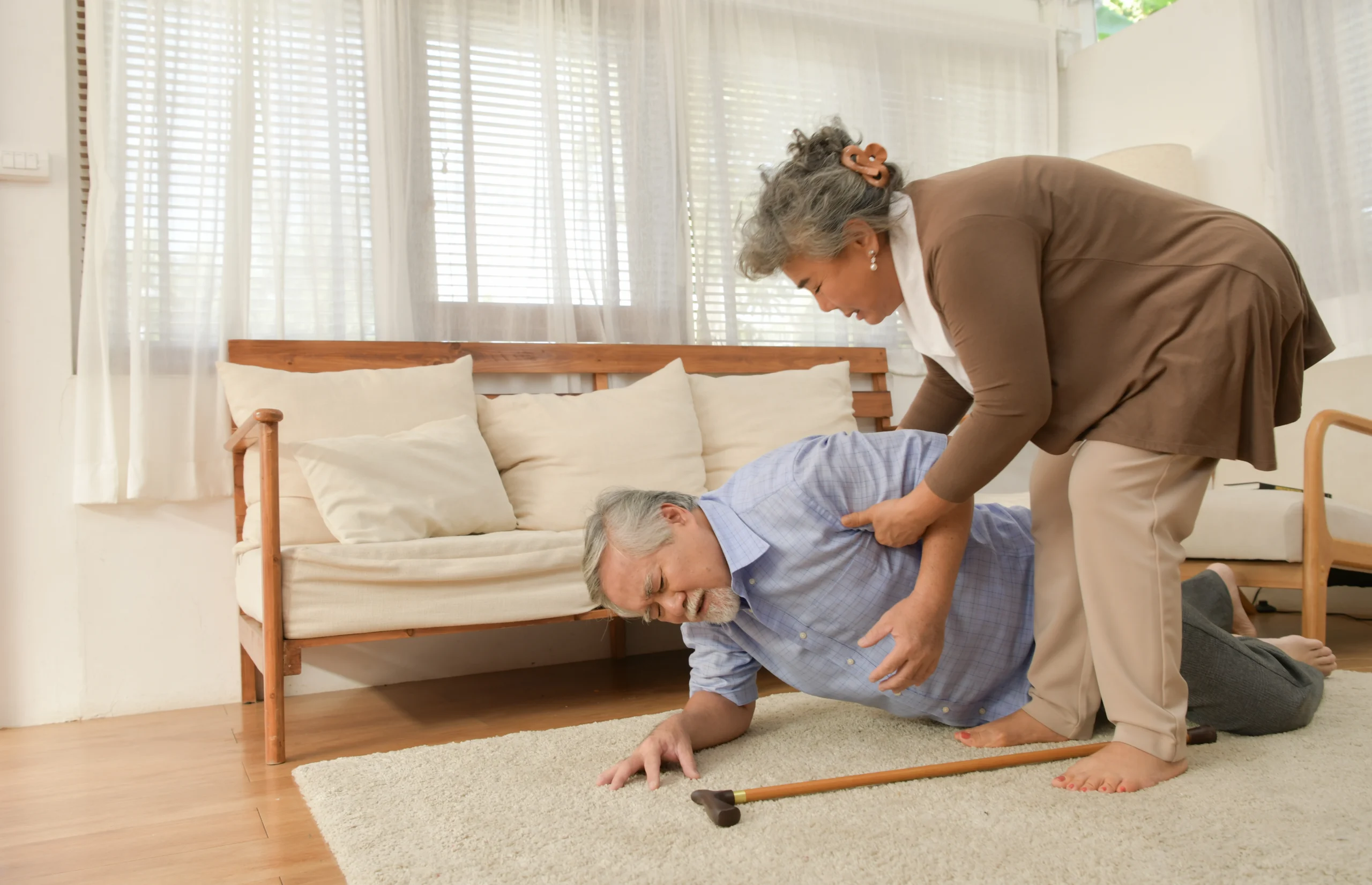 woman helping man off the ground where he has fallen