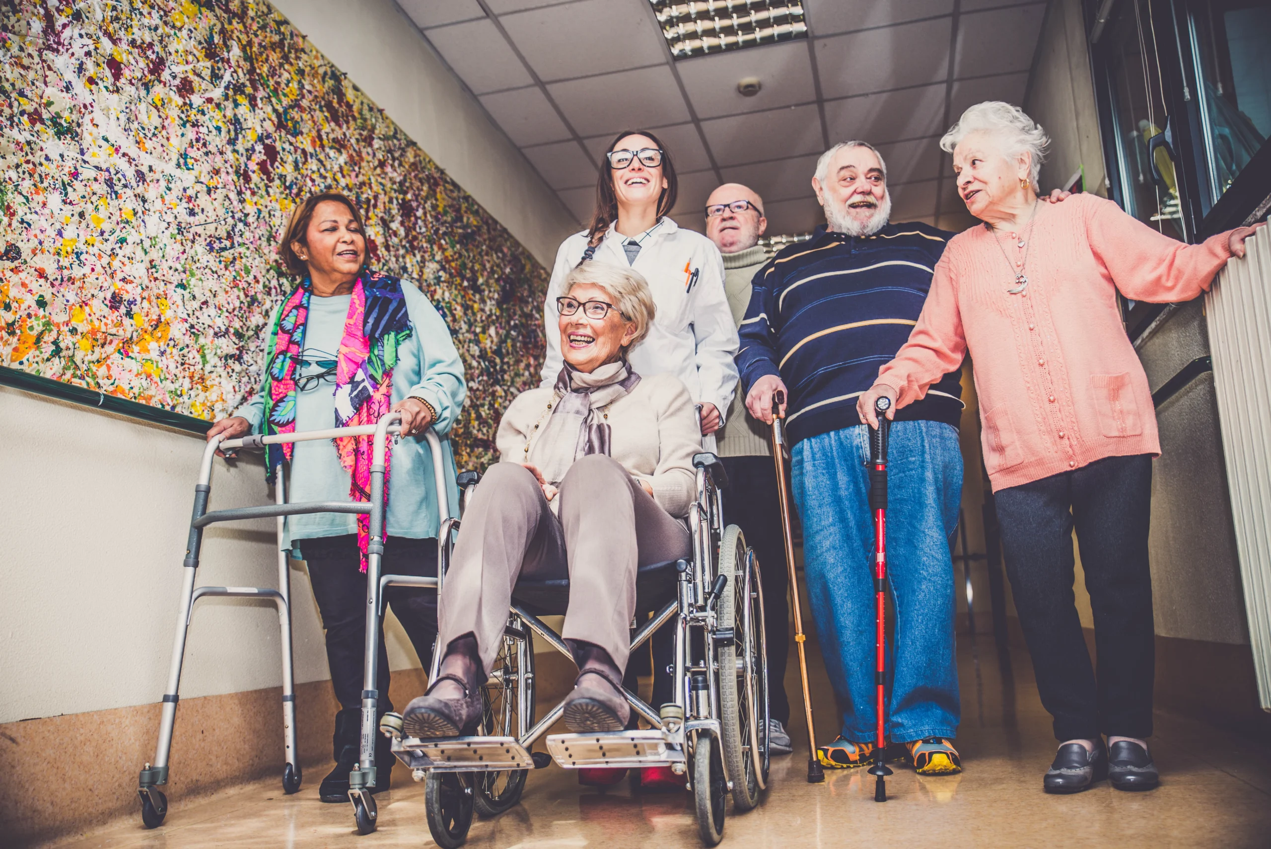 group of elderly folks walking down a hallway with healthcare professional