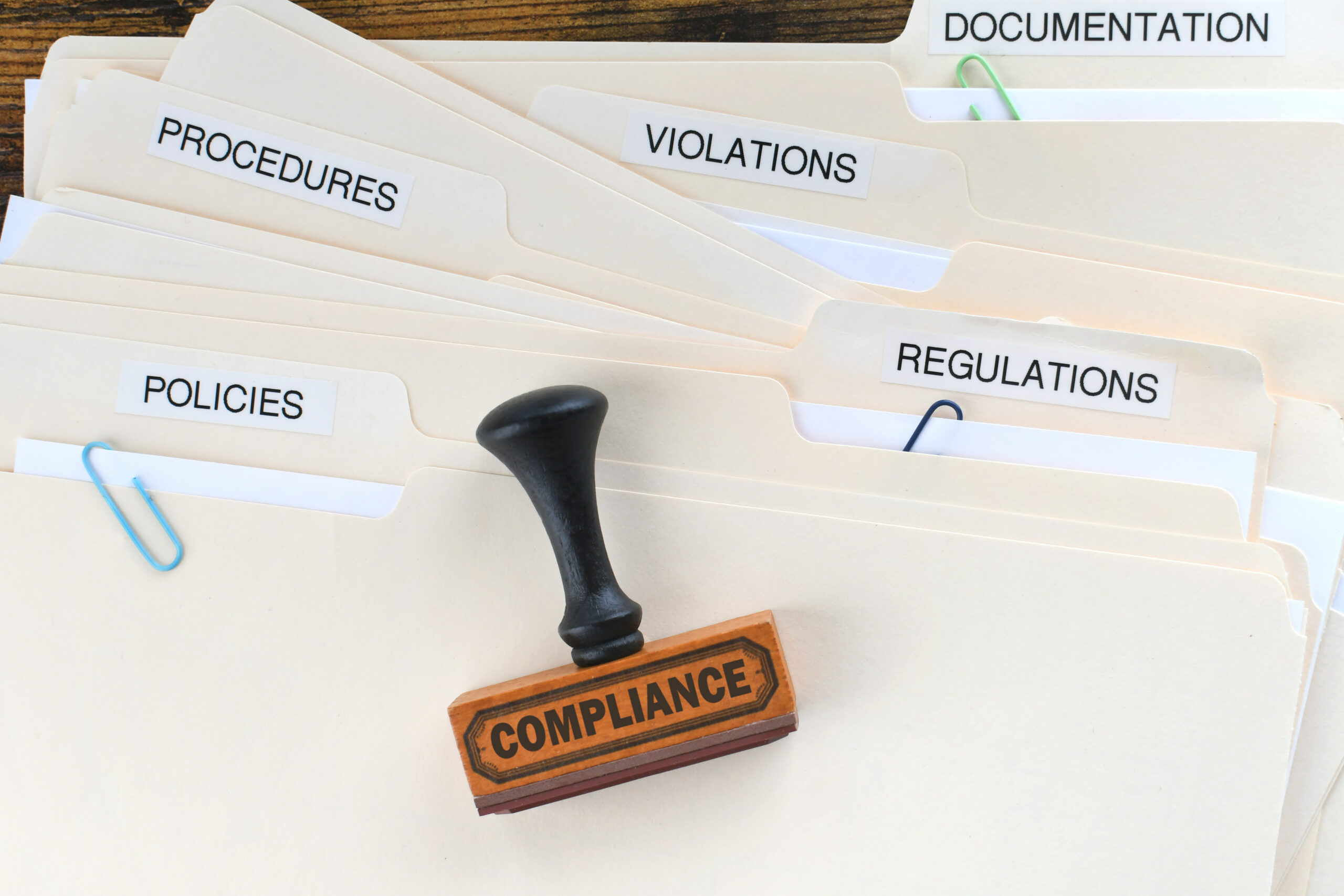 file folders with compliance stamp