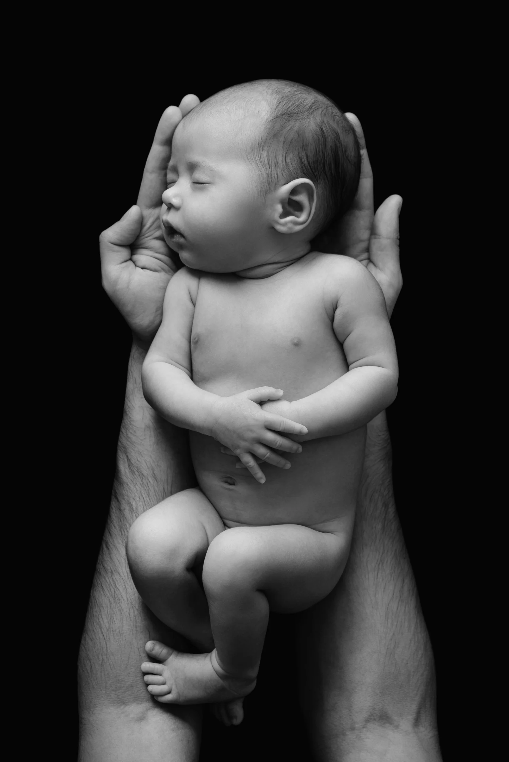 Infant sleeping peacefully in father's arms