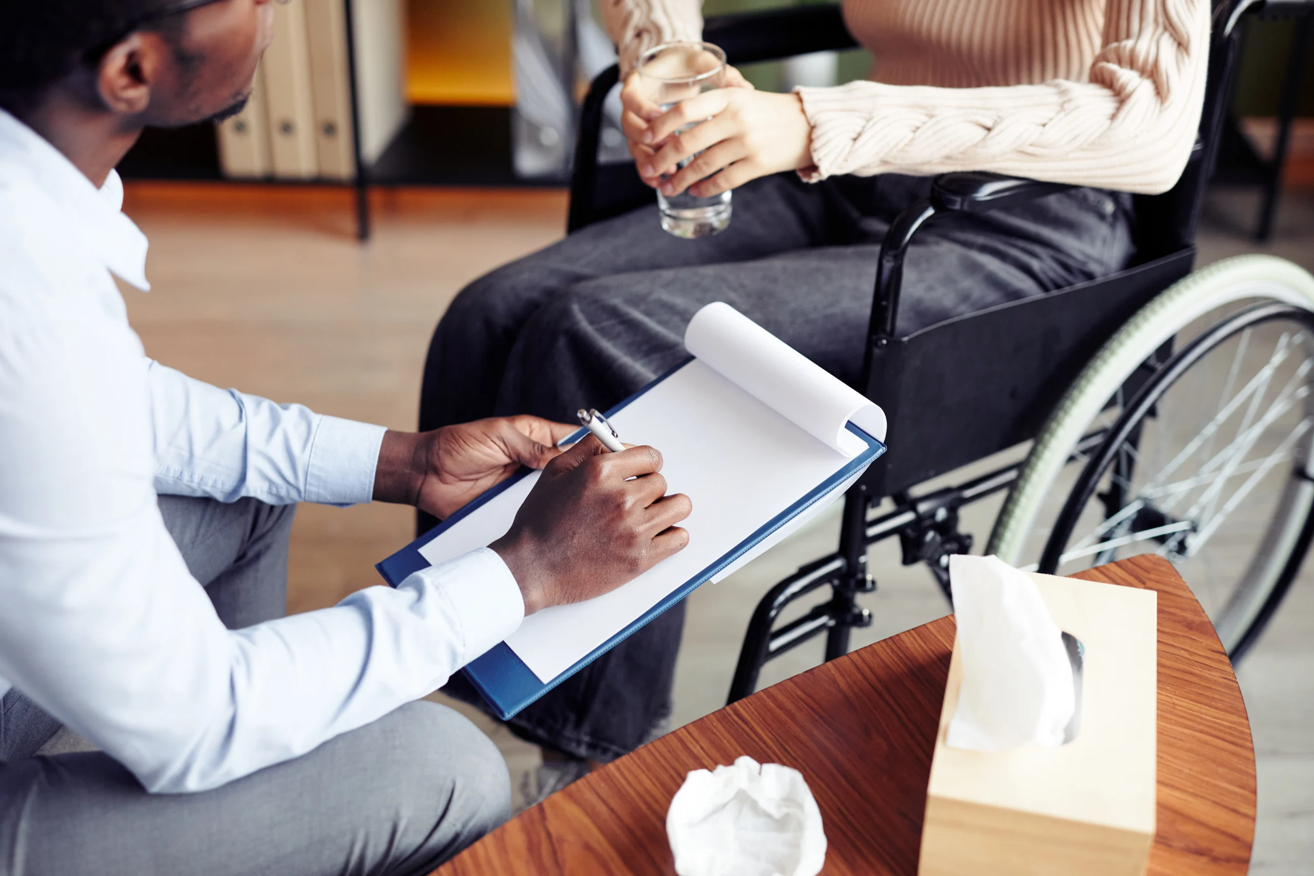 woman talking with therapist holding a clipboard