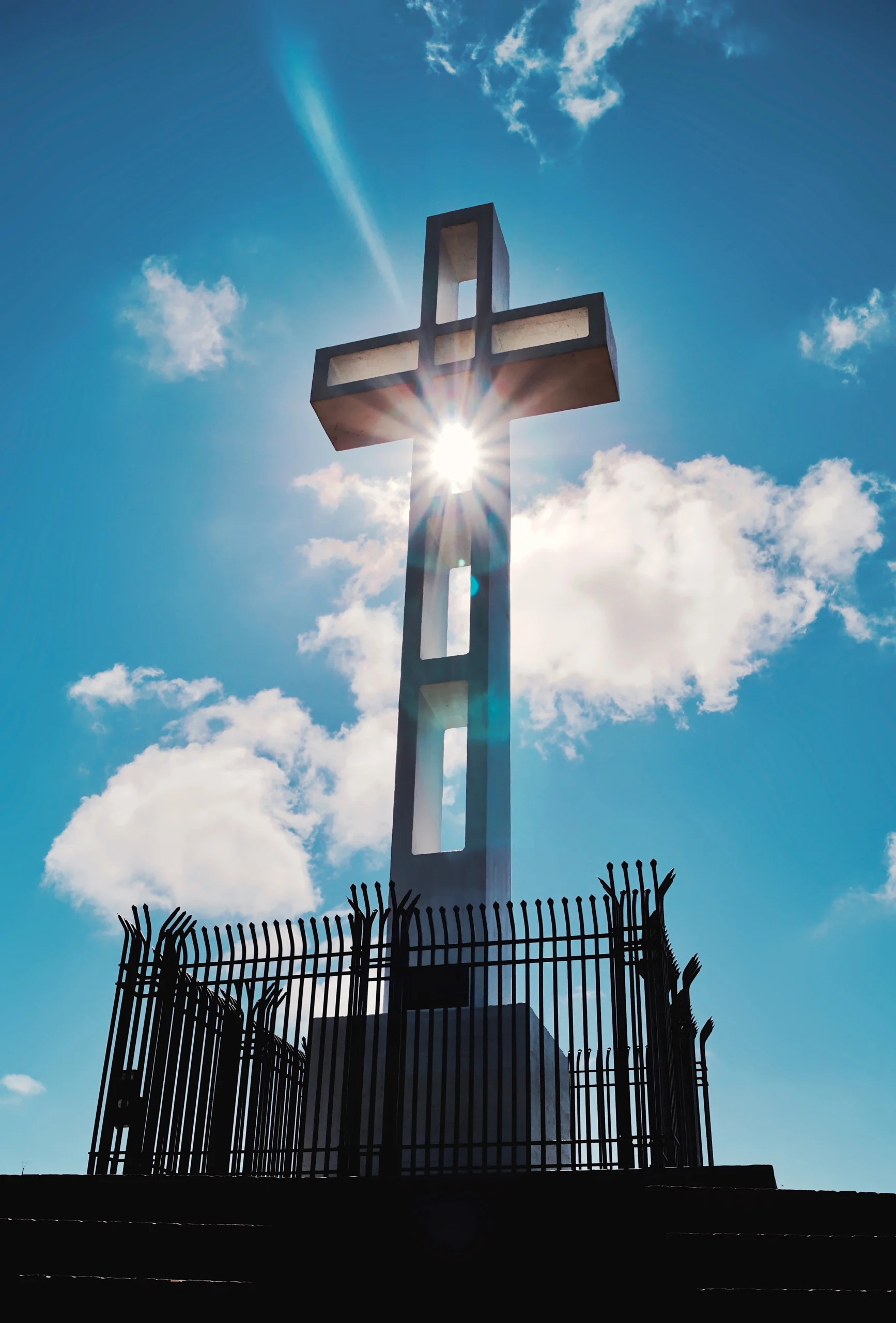 cross with sun peaking through
