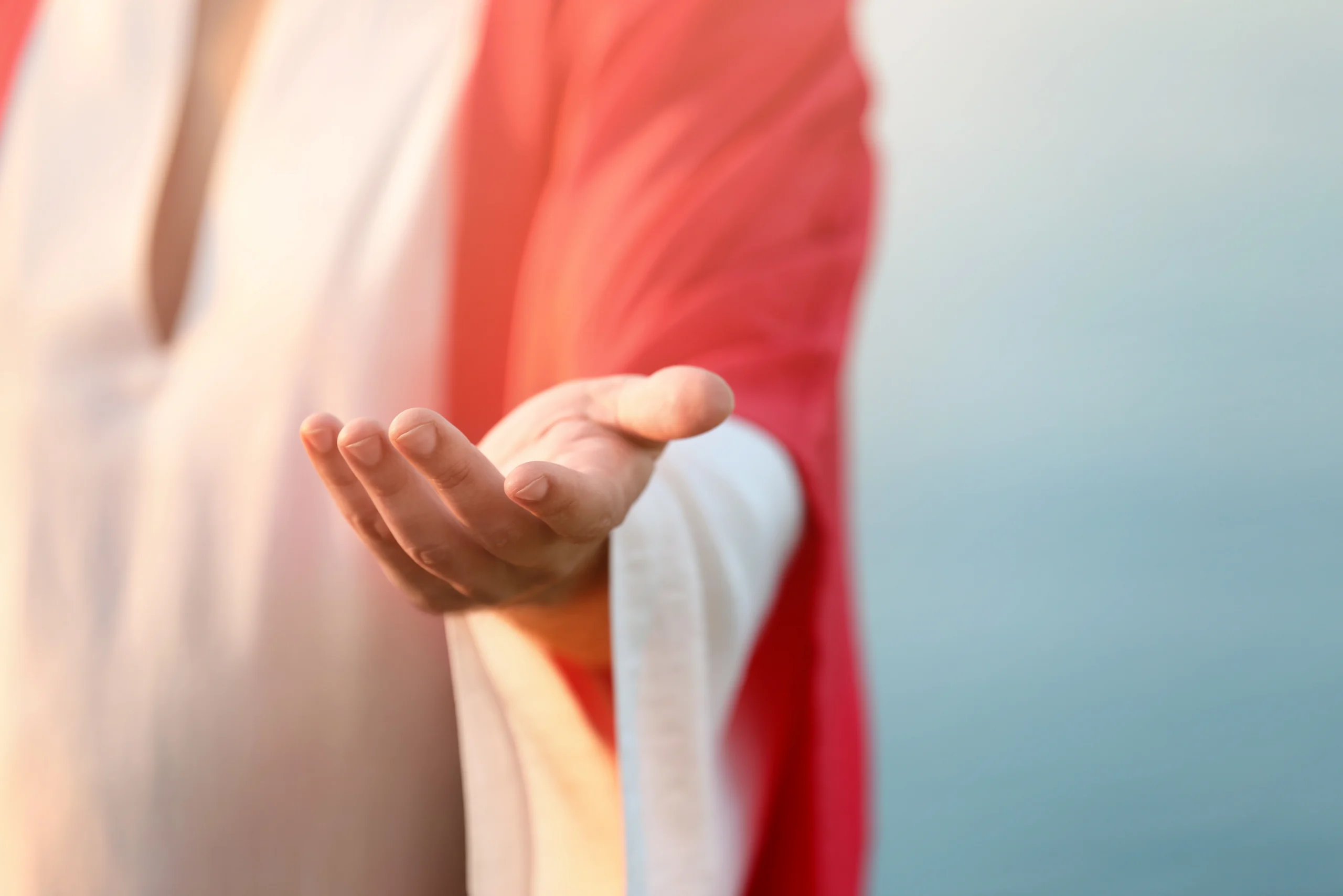 man in a robe holding hands out