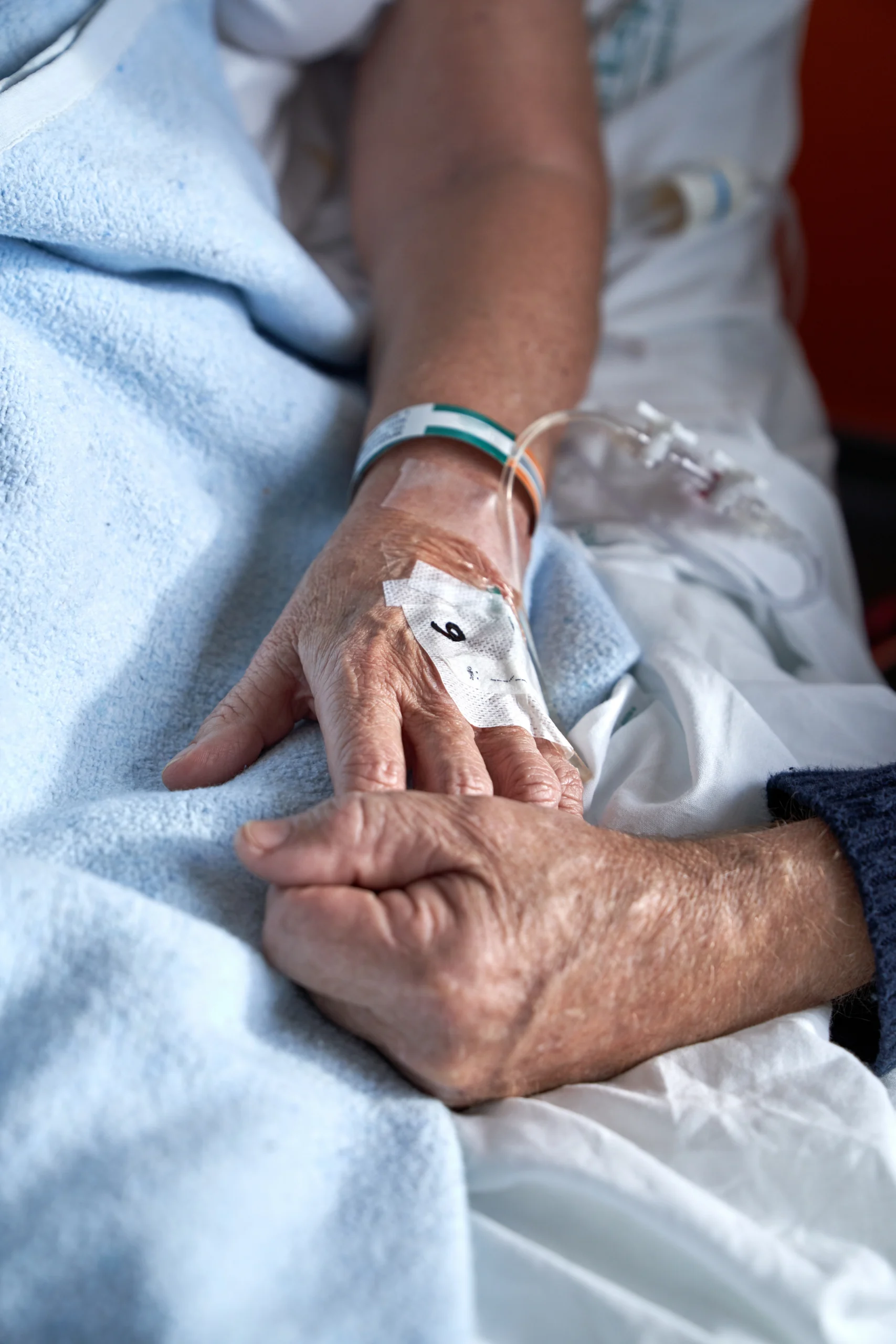elderly couple holding hands in the hospital